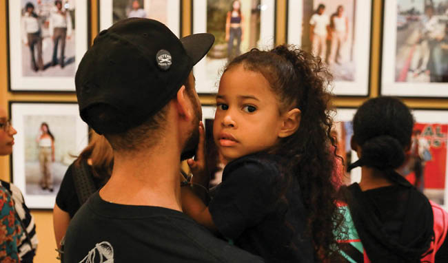 a young man holding a girl at an exhibition