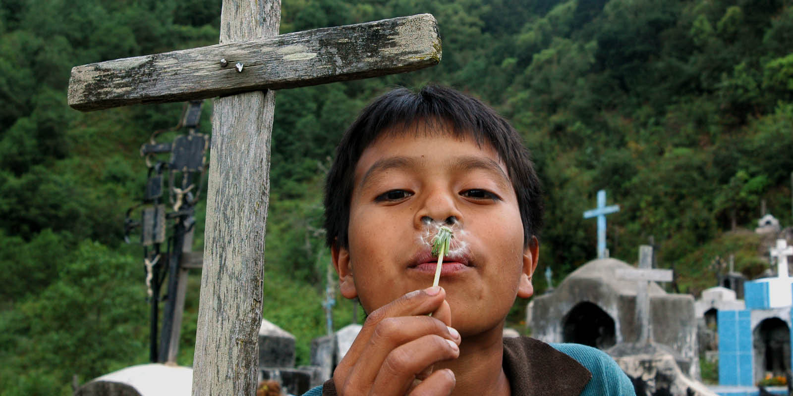 Photo of child celebrating Dia de los Muertos at cemetery