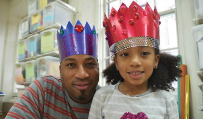 A young man and a girl wearing a paper crown