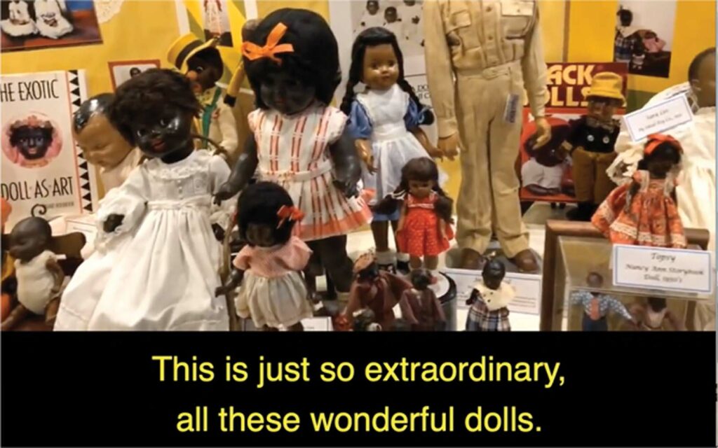 Image capture from video footage that features an exhibition of Black dolls