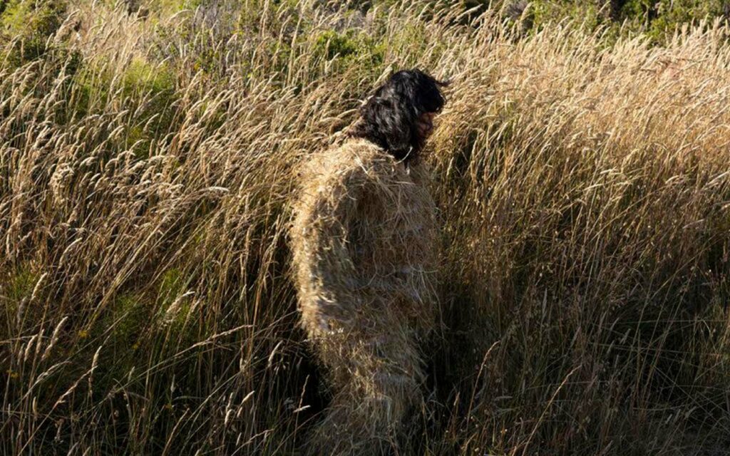 Image a woman camouflaged in a wheat field