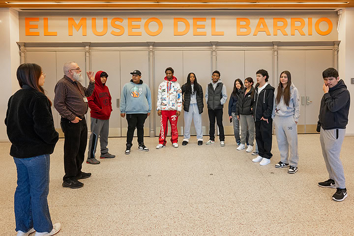 A group of teenagers stand before the entrance to El Museo del Barrio engaged a tour.